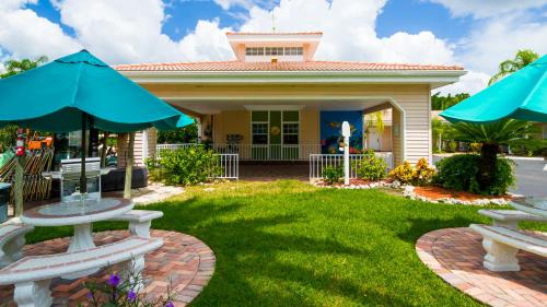 a house with two picnic tables and two umbrellas at Tropical Beach Resorts - Sarasota in Sarasota