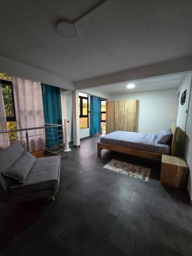 a bedroom with a bed and a couch and a chair at Cozy Haven in Curepipe