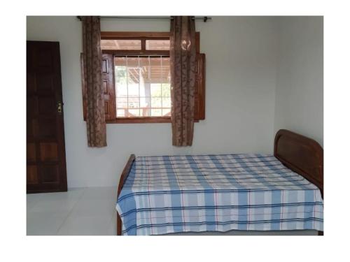 uma cama em um quarto com janela em RESIDÊNCIA MORADA DO SOL em Nova Viçosa