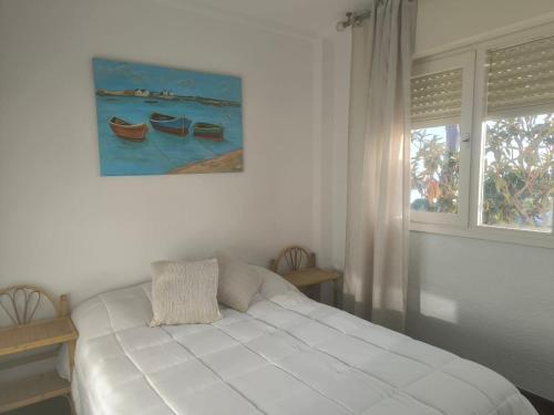 ein weißes Schlafzimmer mit einem Bett und einem Fenster in der Unterkunft Atlantic View Apartment-El Rompido in Cartaya