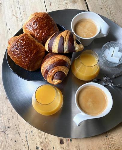 een bord gebak en koffie op een tafel bij maisonnette jacuzzi spa extérieur chauffé 5mn Lille in Saint-André