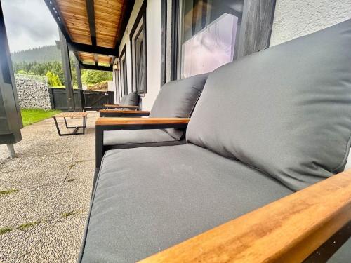 Ferienwohnung "Seeruhe" - Berge, See und Natur am Spitzingsee في شليرزيه: كنب جالس على شرفة بجانب نافذة