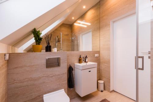 e bagno mansardato con servizi igienici e lavandino. di Warmania-Warmia - balia, sauna, SPA a Międzylesie