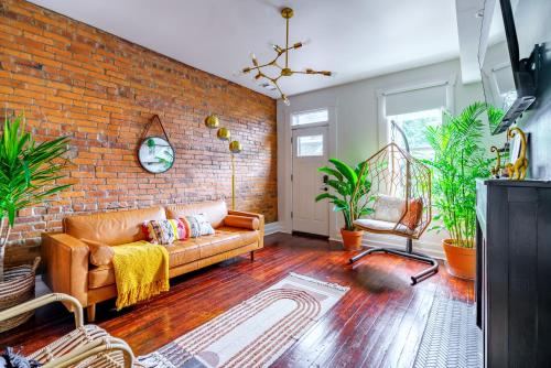 a living room with a couch and a brick wall at Jungle House Luxury Stays - Columbus Downtown Short North in Columbus