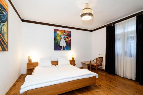 a bedroom with a bed and a painting on the wall at Pension zur Schleuse Kleinmachnow in Kleinmachnow