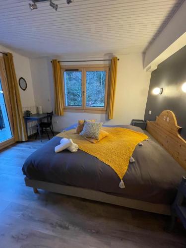 a bedroom with a large bed with a yellow blanket at Hôtel la Kinkerne in Morzine