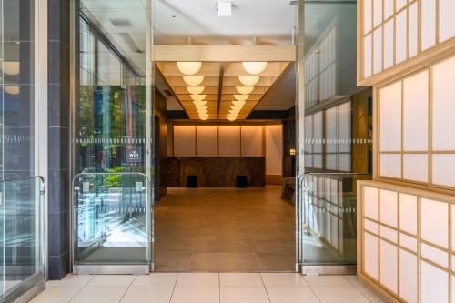 een lege hal in een gebouw met glazen deuren bij Richmond Hotel Asakusa in Tokyo