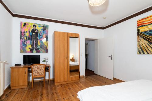 a bedroom with a bed and a desk and a painting at Pension zur Schleuse Kleinmachnow in Kleinmachnow