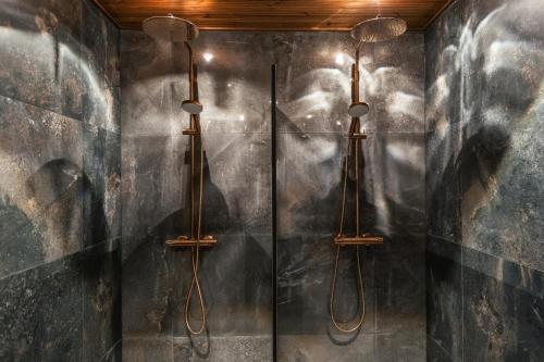 a shower in a bathroom with two lights on the wall at Skýra Retreat in Rovaniemi