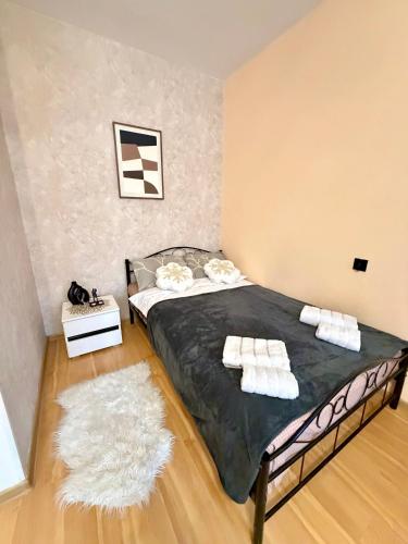a bedroom with a bed with towels and a rug at Rynek Ratusz in Wrocław