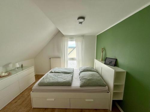 een slaapkamer met een bed en een groene muur bij Haus am Tor zur Eifel in Mechernich