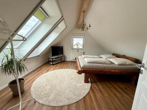 a attic bedroom with a bed and a rug at Haus am Tor zur Eifel in Mechernich