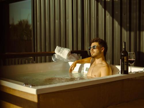 een man in een bad met een fles wijn bij Bodega Iaccarini Wine Lodge by BT Homes in San Rafael