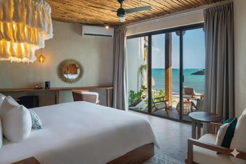a bedroom with a bed and a view of the ocean at Nerea Tulum in Tulum