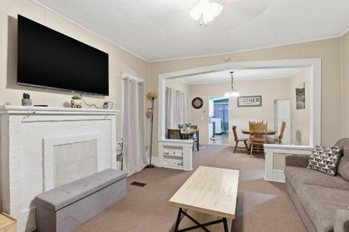 een woonkamer met een open haard en een tv aan de muur bij Cozy Matewan Trail Stay home in Delbarton