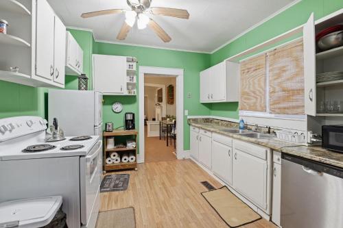 een keuken met witte apparatuur en groene muren bij Cozy Matewan Trail Stay home in Delbarton