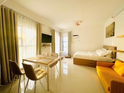 a bedroom with a bed and a table and a couch at YukiDo Skynest in Mactan Island