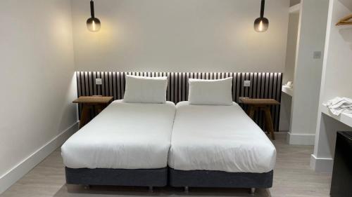 a bed with two pillows on it in a room at RIOSHOUSE Henley in Henley on Thames