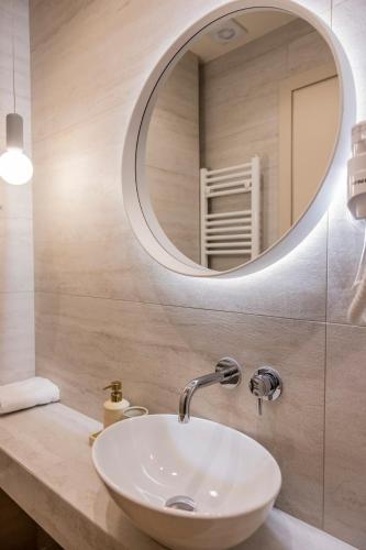 a bathroom with a white sink and a mirror at Andre House Trikala in Méga Kefalóvryson