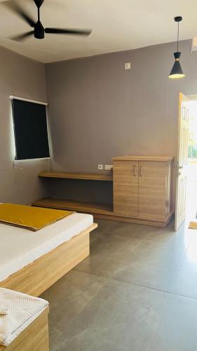 een slaapkamer met twee bedden en een tv aan de muur bij Ocean Resorts in Udupi