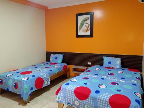 Un dormitorio con dos camas y un cuadro en la pared. en Hotel Lanus, en Portoviejo