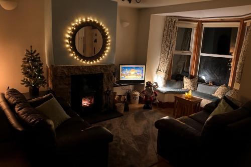 a living room with a fireplace and a mirror at 3 bedroom - Sea View - Pet Friendly in Pistyll