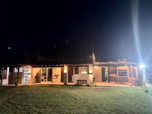 a house at night with a lawn in front of it at Casa Slide en Chapadmalal in Colonia Chapadmalal