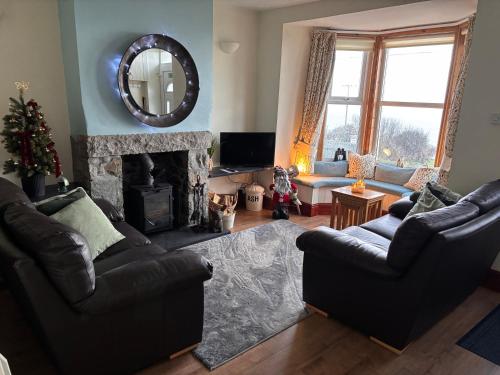 a living room with two couches and a fireplace at 3 bedroom - Sea View - Pet Friendly in Pistyll