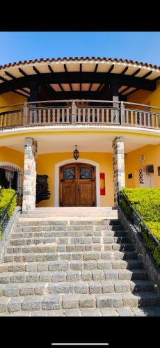 a house with stairs in front of a wooden door at Hotel ALTOS DE ARUNA in Bialet Massé