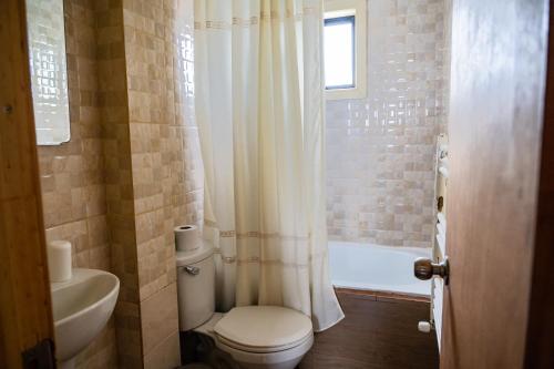 ein Badezimmer mit Toilette, Badewanne und Waschbecken in der Unterkunft Cabañas Sierra Dorotea in Puerto Natales
