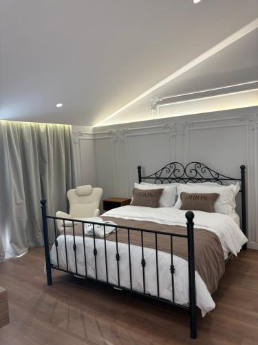 Orion Palace Boutique Hotel في دوريس: غرفة نوم بها سرير كبير وكرسي