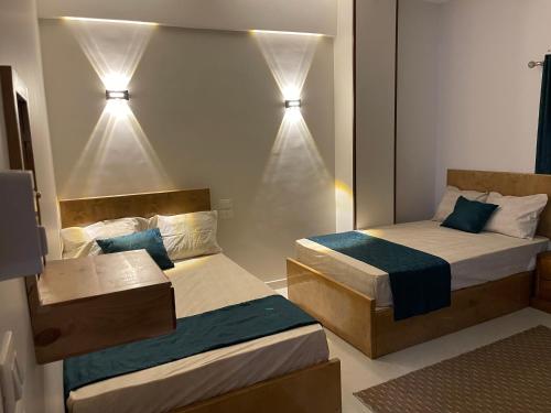 two beds in a room with lights on the wall at Luxe Nest Guest House Apartment 21 in Luxor