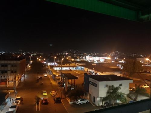 Una ciudad de noche con coches estacionados en un estacionamiento en Hotel Lanus, en Portoviejo