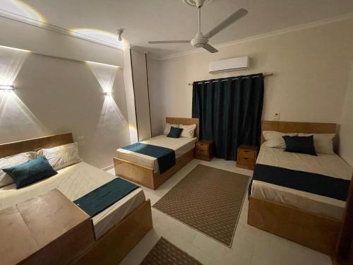 a hotel room with two beds and a window at Luxe Nest Guest House Apartment 21 in Luxor