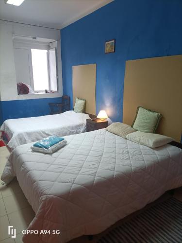 a bedroom with two beds and a blue wall at ViSIT CASTELO BRANCO in Castelo Branco