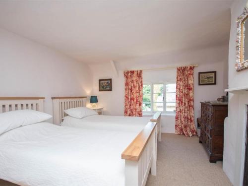 een slaapkamer met twee bedden en een raam bij 3 Bed in Bridport oc-dc059 in Loders