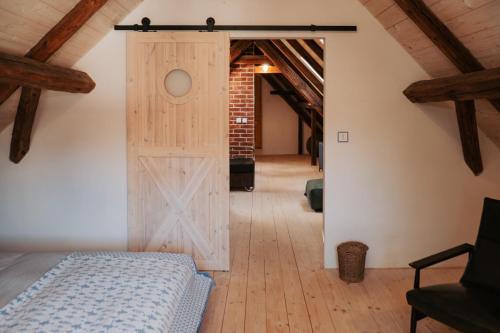 a room with a barn door and a bedroom at Usedlost Ledňáček - Boutique Wellness & SPA in Písečné
