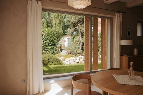 a dining room with a large window and a table and chairs at Usedlost Ledňáček - Boutique Wellness & SPA in Písečné