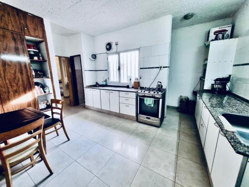 una cucina con mobili bianchi e un forno a piano cottura di La Hélice a Puerto Madryn