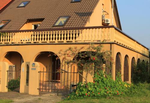a yellow house with a balcony and a plant at Arkady in Słupsk
