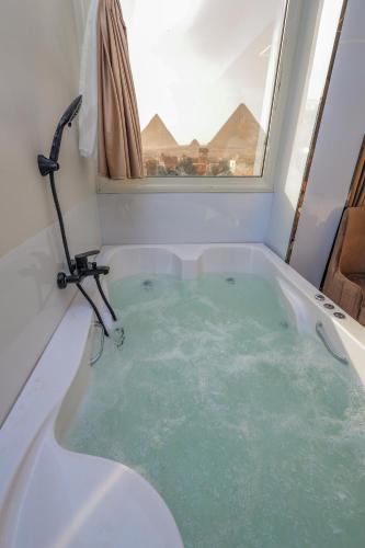 a bath tub filled with green water in a bathroom at First Site OF Pyramids View & Jacuzzi in Cairo