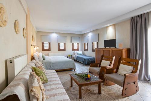 a hotel room with a bed and a living room at Archodiko Toliadi Boutique Apartments and Suites in Ouranoupoli