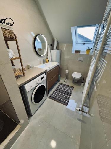 a bathroom with a sink and a washing machine at Apartman Old Corner in Virovitica