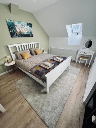 a bedroom with a large white bed with a rug at Apartman Old Corner in Virovitica