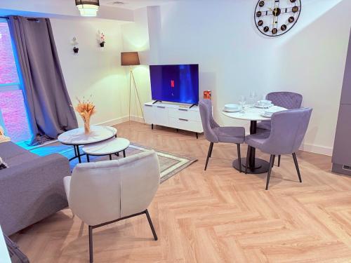 Best Area Stylish1Bed, Games, Relax, Parking في برمنغهام: غرفة معيشة مع طاولة وكراسي وتلفزيون