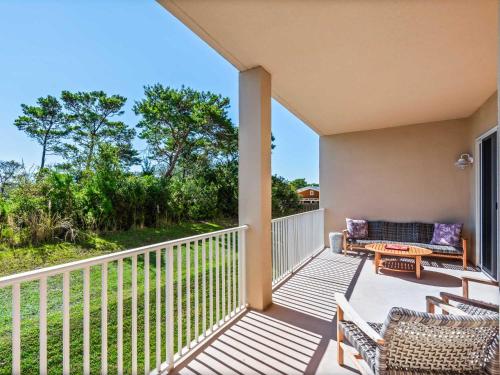 a balcony with chairs and a couch and a table at Sanctuary at Redfish 1106 by Newman-Dailey in Blue Mountain Beach