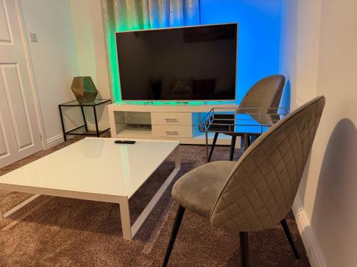 a living room with a white table and chairs and a television at 2 Bedroom Wakefield City Centre House With All Ensuite Rooms in Wakefield