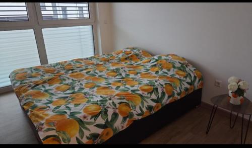 a bedroom with a bed with a flowered blanket at Bright apartment, private parking in Dudelange