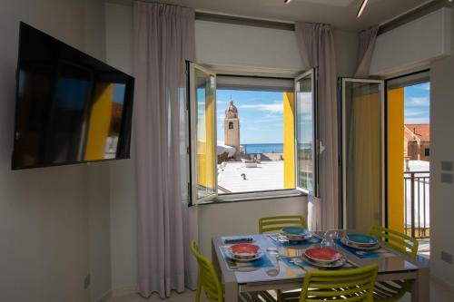 une salle à manger avec une table et une fenêtre dans l'établissement Varicottis Luxury Apartments con parcheggio privato, à Varigotti