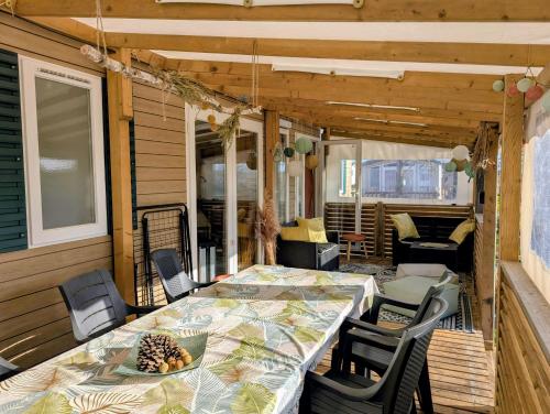 eine Terrasse mit Tisch und Stühlen auf einer Veranda in der Unterkunft Mobil home Apollon Riviera in Saint-Papoul